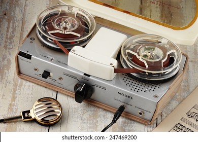 Vintage Portable Tape Recorder With Microphone On Aged Table