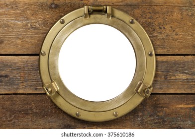 Vintage porthole with clipping path. old brass porthole in wooden wall, window isolated with clipping path