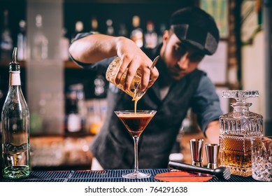 Vintage Portrait Of Bartender Creating Cocktails At Bar. Close Up Of Alcoholic Beverage Preparation