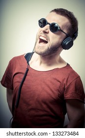 Vintage Portrait Of Fashion Guy With Headphones And Sunglasses On Gray Background