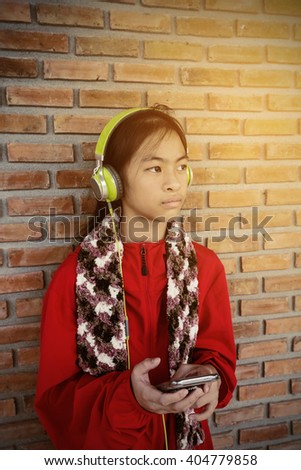 vintage Portrait of teen girl listening sad music from a smartphone 