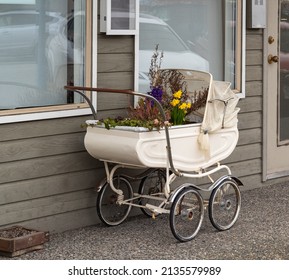 Vintage Pram Baby. Baby stroller decorated with flowers. Vintage baby stroller in beautiful interior with original decoration. Street phot, nobody, selective focus