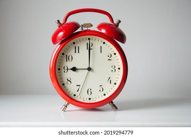 Vintage red alarm clock showing 9 am on white background - Shutterstock ID 2019294779