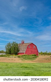 Vintage Red Barn In A Farmyard On The Prairies In Saskatchewan