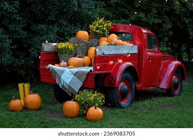 A vintage red classic old truck filled season flowers hay and festive fall orange pumpkins.  - Powered by Shutterstock