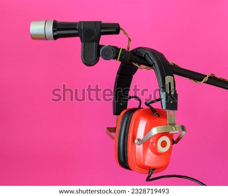 Vintage red headphone and old microphone on pink background, podcast,recording sound,vinatge audio gear concept. Free copy space.