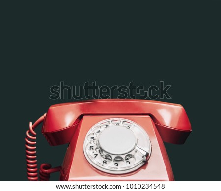 An old red telephone over red background