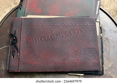 Vintage, Red, Weathered Photo Albums On A Table At An Estate Sale.