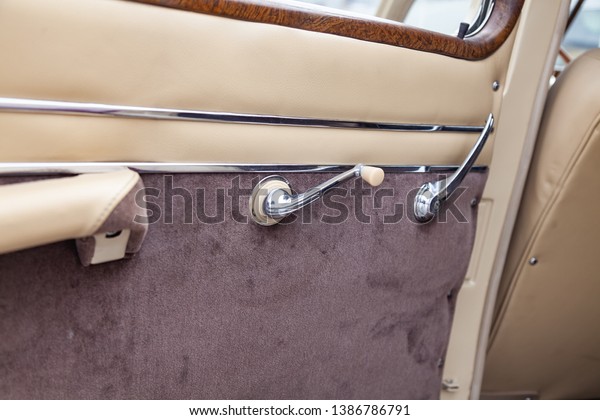 Vintage retro car\
door dashboard with analog handle and switch for winbow of leather\
and carpet trim, handmade with wood and chrome for restoration.\
Auto service industry.