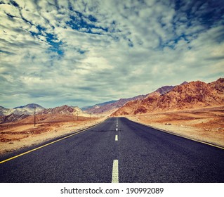 Vintage Retro Effect Filtered Hipster Style Travel Image Of Travel Forward Concept Background - Road In Himalayas With Mountains And Dramatic Clouds. Ladakh, Jammu And Kashmir, India