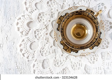 Vintage Retro Empty Cup On Doily On White Old Wooden Table