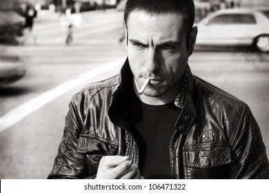 Vintage retro style black and white portrait of a tough sexy guy in leather jacket