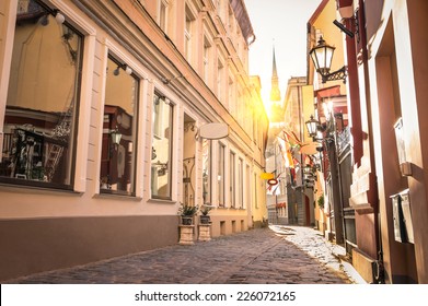 Vintage retro travel image of a narrow medieval street in old town Riga at sunset - Latvia - European capital of culture 2014 - Warm retro filtered look - Powered by Shutterstock