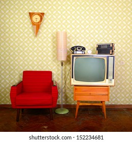 Vintage room with wallpaper, old fashioned armchair, retro tv, phone, clocks, radio player and standart lamp 