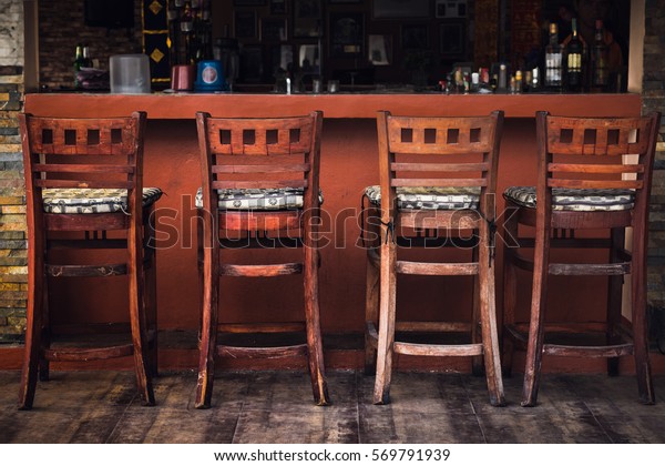 Vintage Row of wooden\
chairs, Interior background , Brown wooden chairs near the wooden\
bar of the bar