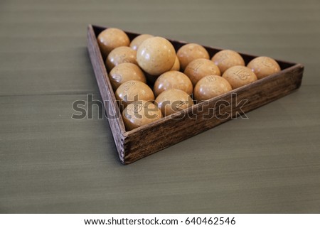 Vintage Russian billiard balls lay on green cloth in a triangle frame. Vintage stylized photo