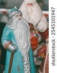 Vintage Russian Santa Claus (Father Frost) figurine in blue coat, holding a bag with a book titled "Fairy Tales" and a small bear. Classic Eastern European New Year decoration, nostalgic holiday charm