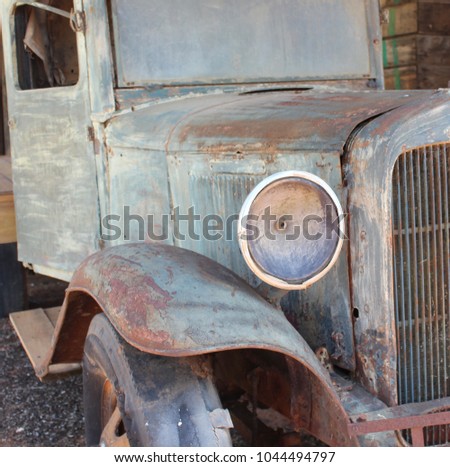 VINTAGE RUSTED UTE TRANSPORT WITH OLD HEADLIGHT AND DETERIORATED RUBBER TYRE, PALE GREEN RUST METAL