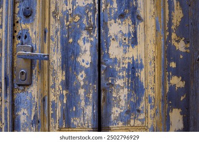 Vintage rustic door with a metallic lock and door handle. Detailed old wooden texture with chipped paint and a worn-out surface. Antique doorknob design. Backdrop for creative projects. Copy space - Powered by Shutterstock