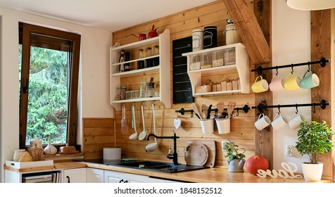 Vintage rustic kitchen in wooden cottage with window and kitchenware. Interior with wooden wall and mug in rural style. Banner - Shutterstock ID 1848152512