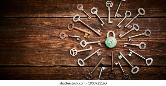 Vintage rusty padlock surrounded by group of old keys on a weathered wooden background. Internet security and data protection concept, blockchain and cybersecurity. Lockdown. Escape route and room

