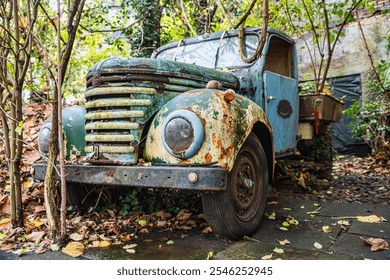 A vintage rusty truck sits abandoned, from the time of world war two,enveloped by lush greenery and vines, creating a picturesque scene of nature reclaiming man-made objects. - Powered by Shutterstock