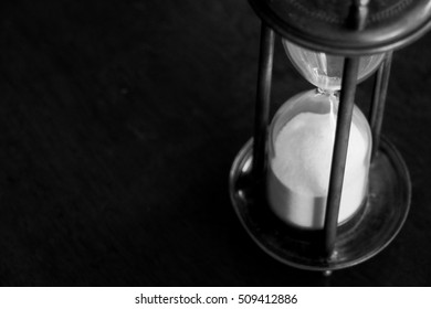 Vintage Sandglass Or Hourglass Or Egg Timer On Wooden Table In Black And White Photo Showing Run Out Of Time Concept, View From Above