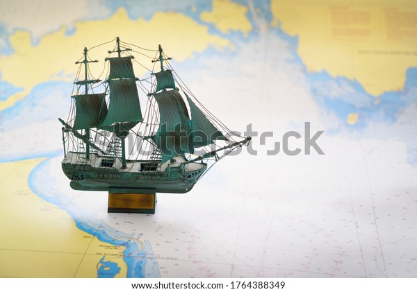 Vintage scale
model of the historical tall ship and old white nautical chart
close-up. Planning travel, sailing accessories, concept art,
graphic resources, objects,
collecting