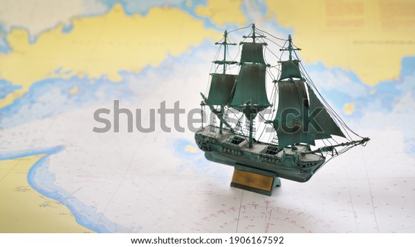 Vintage scale\
model of the historical tall ship and old white nautical chart\
close-up. Planning travel, sailing accessories, concept art,\
graphic resources, objects,\
collecting