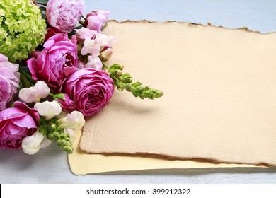Vintage sheets of paper and bouquet of flowers, copy space. Blank space for greetings.