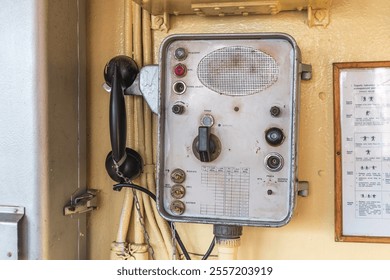 Vintage ship communication panel with a black rotary phone, speaker, dials, and Polish text labels. - Powered by Shutterstock