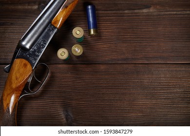 Vintage shotgun and ammunition on a wooden background.