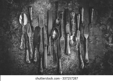 Vintage silver cookware arrange on a full dark rustic background. white black image.
rustic style. 
