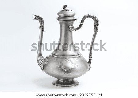 Vintage silver jug lamp teapot on a white background. Antique metal vessel with spout and handle side view. East tableware.