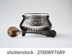 Vintage silver salt cellar with spoon on light background. Silverware