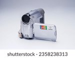 a vintage silver video camcorder camera from the 90s with colorful sticker in grey background isolated