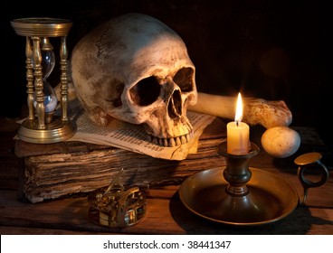 Vintage skull on antique book with candle and hourglass