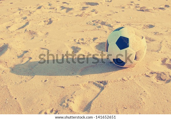 Vintage Soccer ball on\
sand