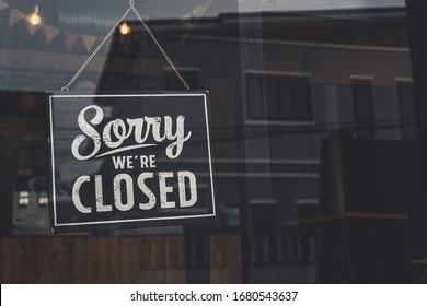 Vintage sorry we are closed sign hanging on a glass door. - Shutterstock ID 1680543637