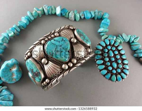 Vintage\
Southwestern jewelry display with large chunky turquoise cuff\
bracelet and large old cluster turquoise\
ring.