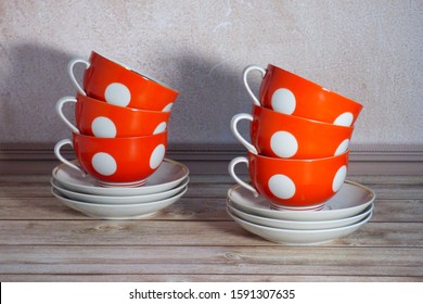 vintage soviet two piles of three red cups in white circles standing on a stack of saucers on a wooden table
