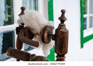 Vintage spinning wheel with a bundle of yarn in close-up. Vintage device for making woolen fabrics - Powered by Shutterstock