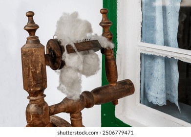 Vintage spinning wheel with a bundle of yarn in close-up. Vintage device for making woolen fabrics - Powered by Shutterstock