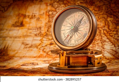 Vintage still life. Vintage compass lies on an ancient world map. - Shutterstock ID 382895257
