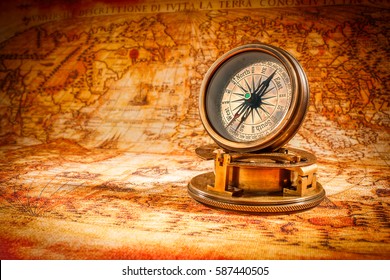 Vintage still life. Vintage compass lies on an ancient world map in 1565. - Shutterstock ID 587440505