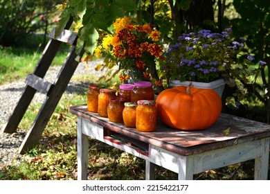 Vintage Still Life With Jars Of Pumkin Jam And Fall Flowers On The Old Table In The Garden Outside, Thanksgiving Day And Calendar Autumn Concept Background