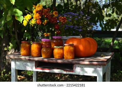 Vintage Still Life With Jars Of Pumkin Jam And Fall Flowers On The Old Table In The Garden Outside, Thanksgiving Day And Calendar Autumn Concept Background