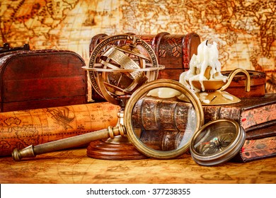 Vintage still life. Vintage magnifying glass lies, pocket watch, old book and armillary sphere on an ancient world map in 1565.