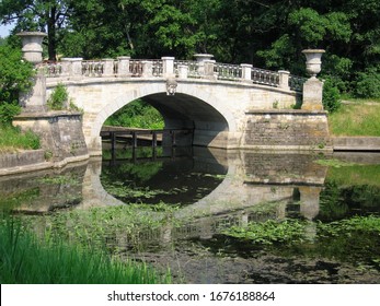 Vintage stone river bridge in a country park on summer sunny day