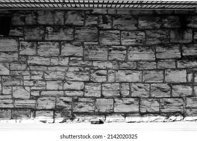 Vintage Stone Wall Of An Old Inner City Building Suffering From Decades Of Neglect In Black And White..